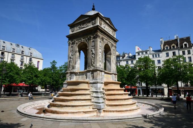 nelisivuinen avoin monumentti, jossa on kuusi askelta molemmilla puolilla, kohti suihkulähteen tai kellon kohtaa