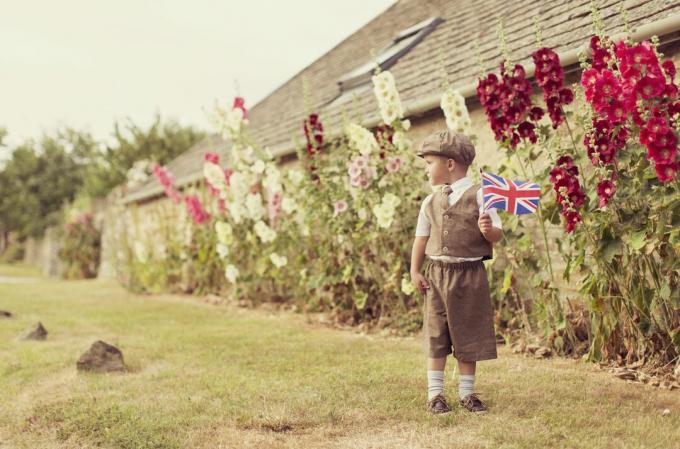 Vintage brittiläinen poika seisoo Union Jackin kanssa