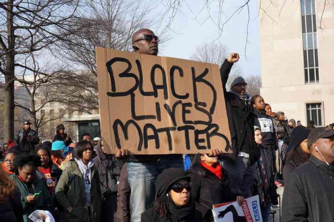 Mies, joka protestoi Michael Brownin, Eric Garnerin ja Tamir Ricen kuolemaa, näyttää Black Lives Matter Washington DC: ssä.