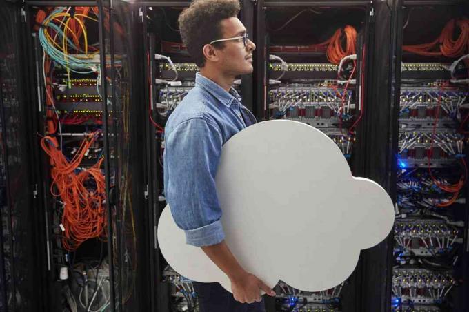 Mies IT-teknikko, joka kuljettaa pilviä palvelintilassa, pilvipalveluja