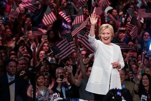 Hillary Clinton aaltoilee väkijoukon edessä heiluttaen Yhdysvaltain lippuja