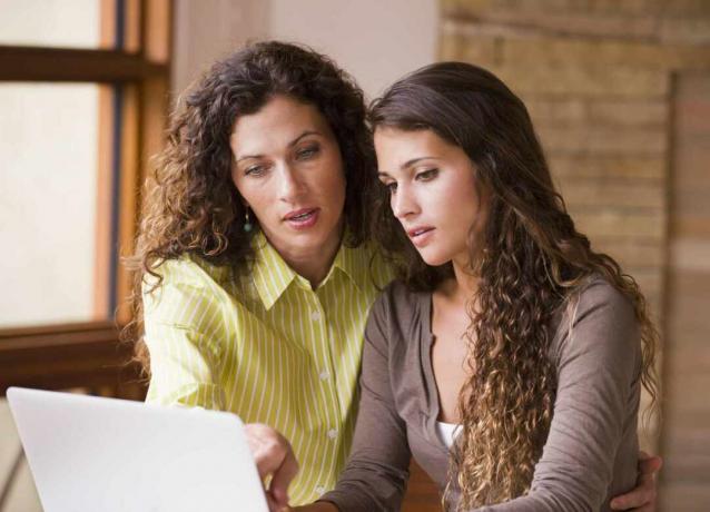 Dos mujeres llenando planilla ja computadora