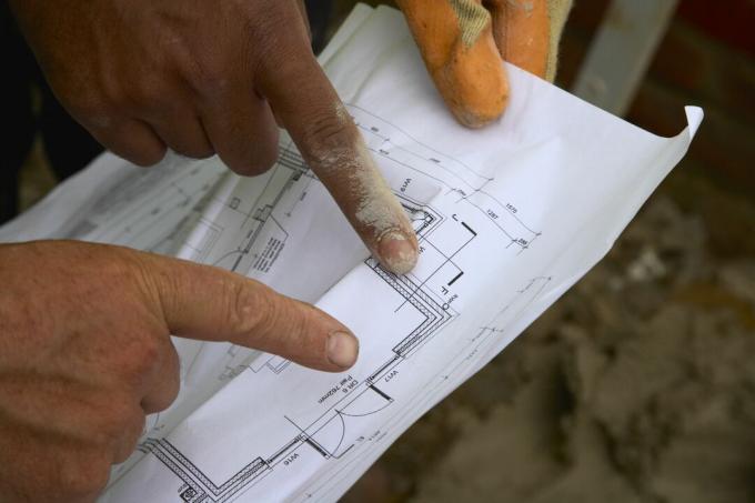 Rakennustyöntekijät, jotka katsovat suunnitelmia, kaikki mitä näet ovat heidän sormensa osoittavat