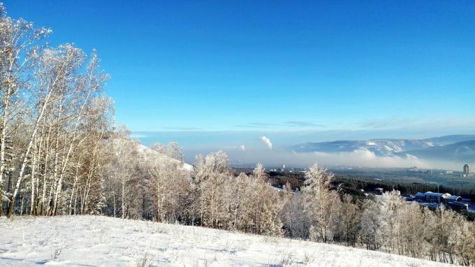 Luonnonkaunis näkymä lumipeitteiseen maisemaan sinistä taivasta vasten