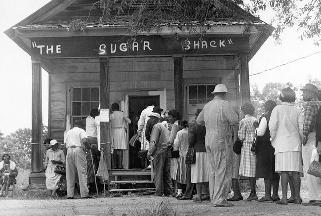 Afroamerikkalaiset äänestäjät, jotka voivat äänestää ensimmäistä kertaa Wilcox Countyn maaseudulla Alabamassa, asettuvat jonoon äänestyspaikan edessä sen jälkeen, kun liittovaltion äänioikeuslaki hyväksyttiin vuonna 1965.