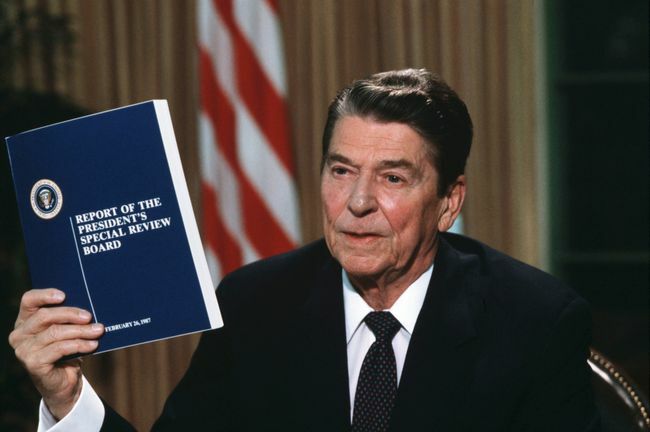 Presidentti Ronald Reagan pitää hallussaan kopiota Tower-komission raportista Iran-Contra-skandaalista
