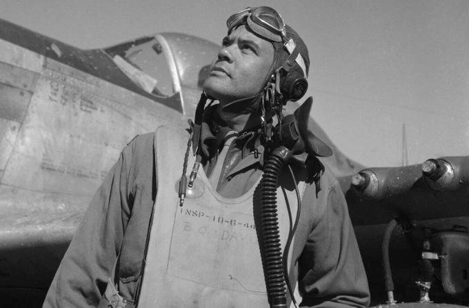 Benjamin O. Davis lentoasussa ja kypärä seisoo P-51 Mustang -hävittäjän edessä.