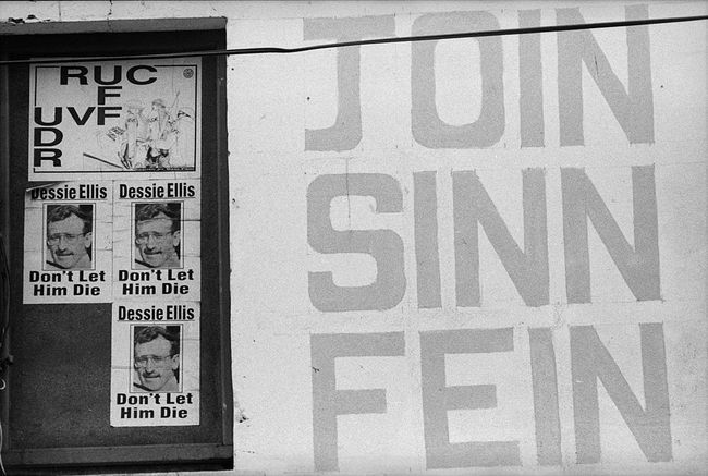 Pohjois-Irlannin julisteita, jotka tukevat poliittista puoluetta Sinn Fein ja vertaavat Pohjois-Irlannin poliisivoimia Britannian armeijaan.