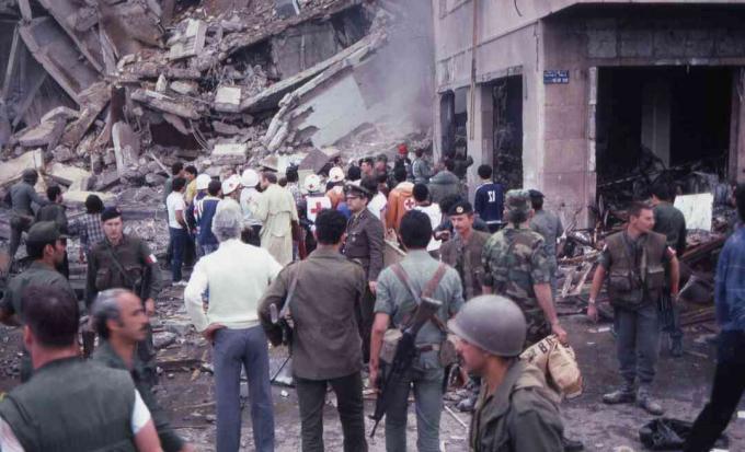 Joukko sotilaita ja avunantajia seisoo keskellä Yhdysvaltain suurlähetystön, Beirutin, Libanonin, 18. huhtikuuta 1983 suoritetun itsemurhapommituksen tuhoa ja vahinkoa.